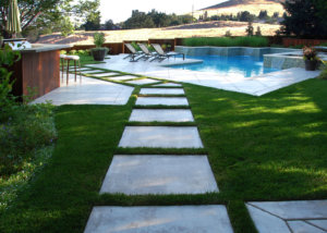 Stone tile on medium grass, with stone tile patio and pool deck