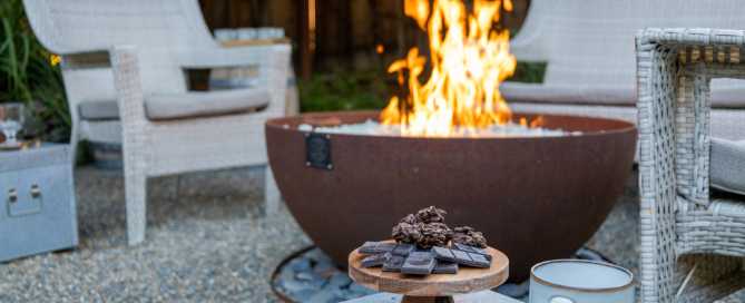 Casual corten steel firebowl set in river rock ring