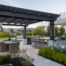 Entry path to outdoor living areas flanked by planting, showing structure of pergola and rooftop deck