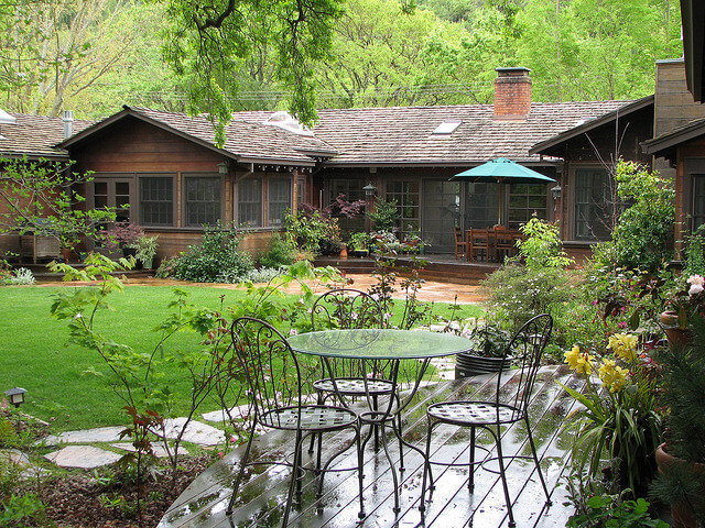 Patio chairs look out over a lush traditional garden