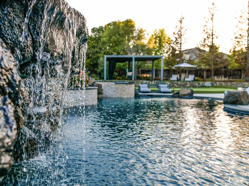 Waterfall cascades form elevated spa into lower pool