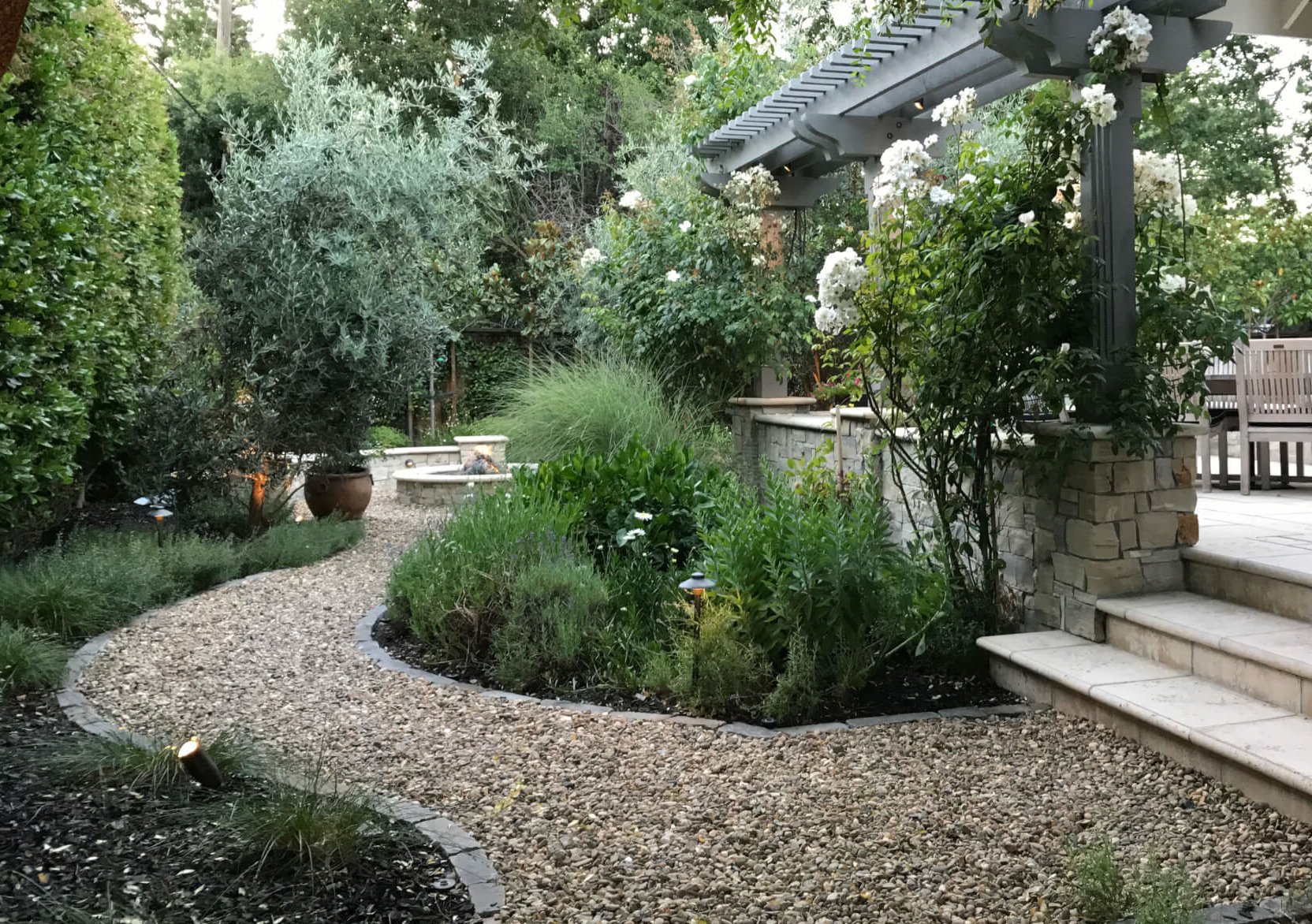 Gravel pathways flow through a Mediterranean landscape of greens and grays.