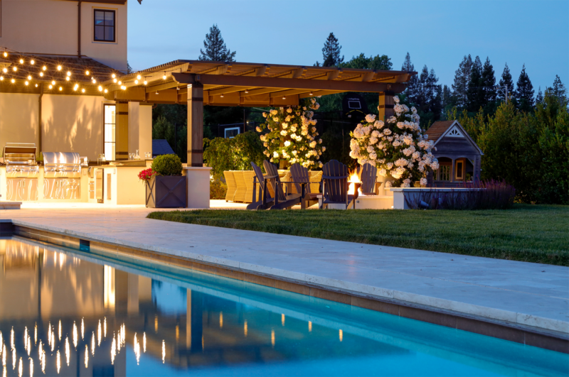 Infinity-edge reflecting pool with golden hills and vineyard in Sonoma-style landscape