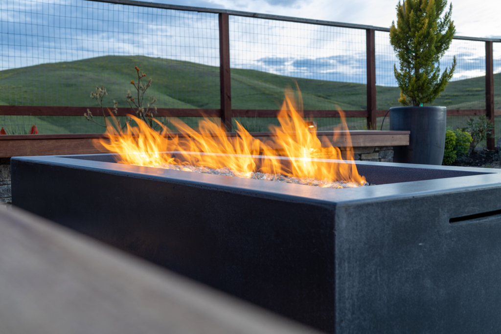 Contemporary cast concrete fire feature with view of rolling hills