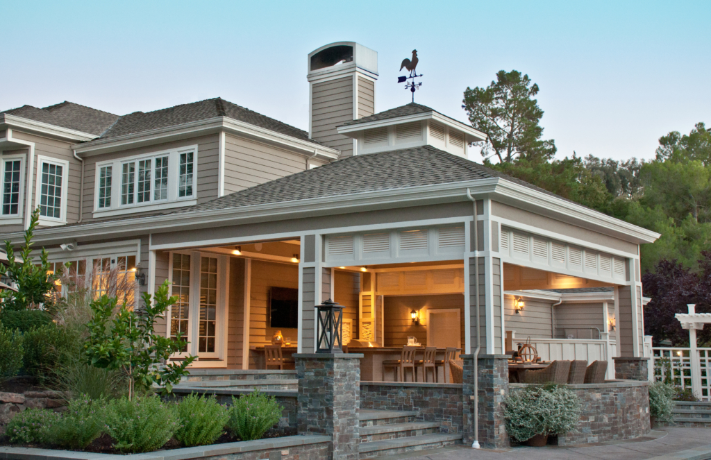Elegant outdoor living space with covered dining area and custom architecture by Montgomery Robbins