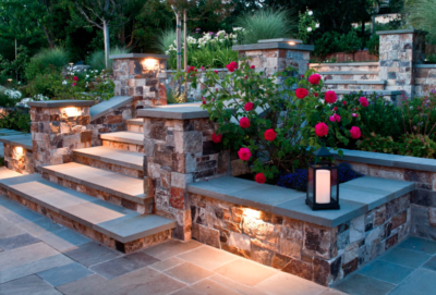 Stone staircase terrace with dark pink roses and glowing landscape lighting