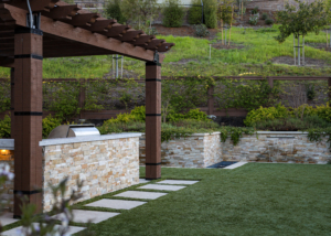 Custom wood pergola and stone accented retaining and bar lend elegance and structure