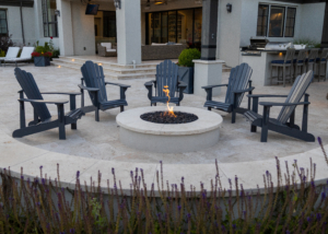 Round fire feature with curved retaining wall and Adirondack chairs on patio