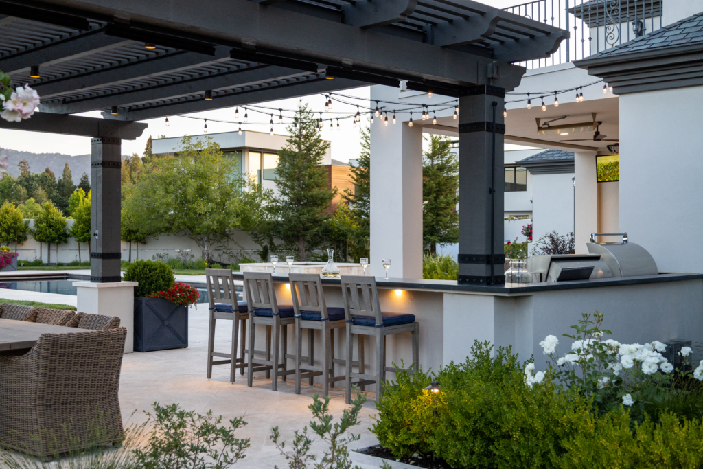 Cookbooks and garden vegetables on outdoor countertop by Montgomery Robbins