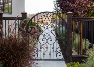 Ornate metal accent gate to side garden with burgundy and silver planting