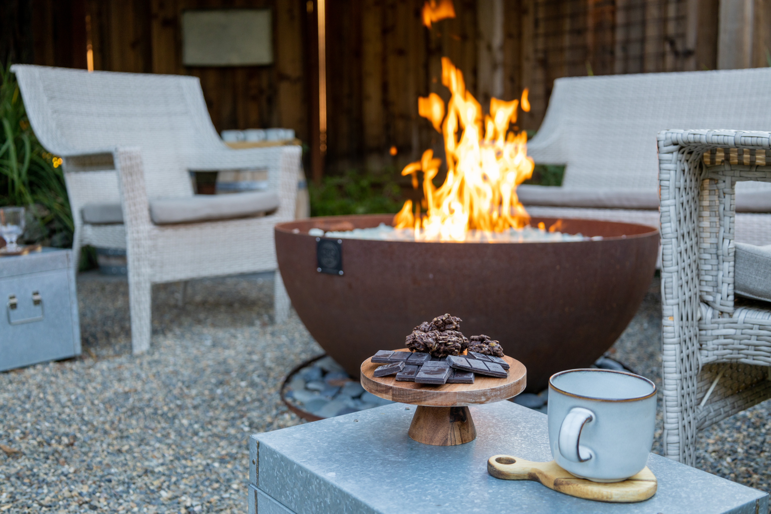 Corten steel fire bowl in gravel seating area