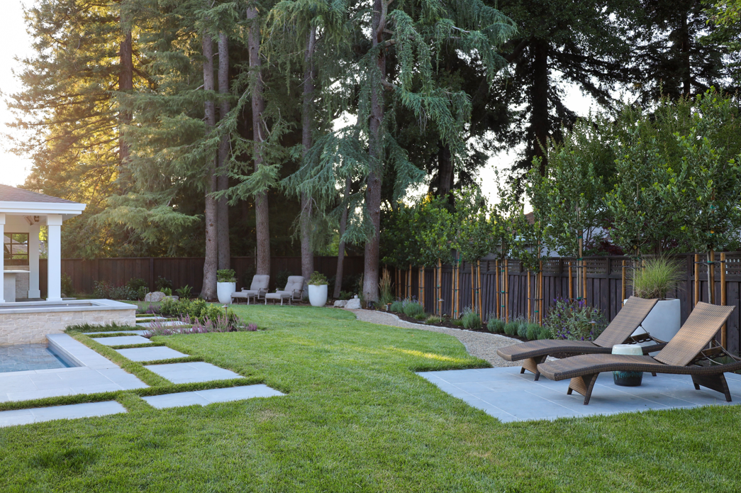 Decorative metal drain cover by Urban Accessories set in interlocking pavers, integrated into a hardscape design by Montgomery Robbins
