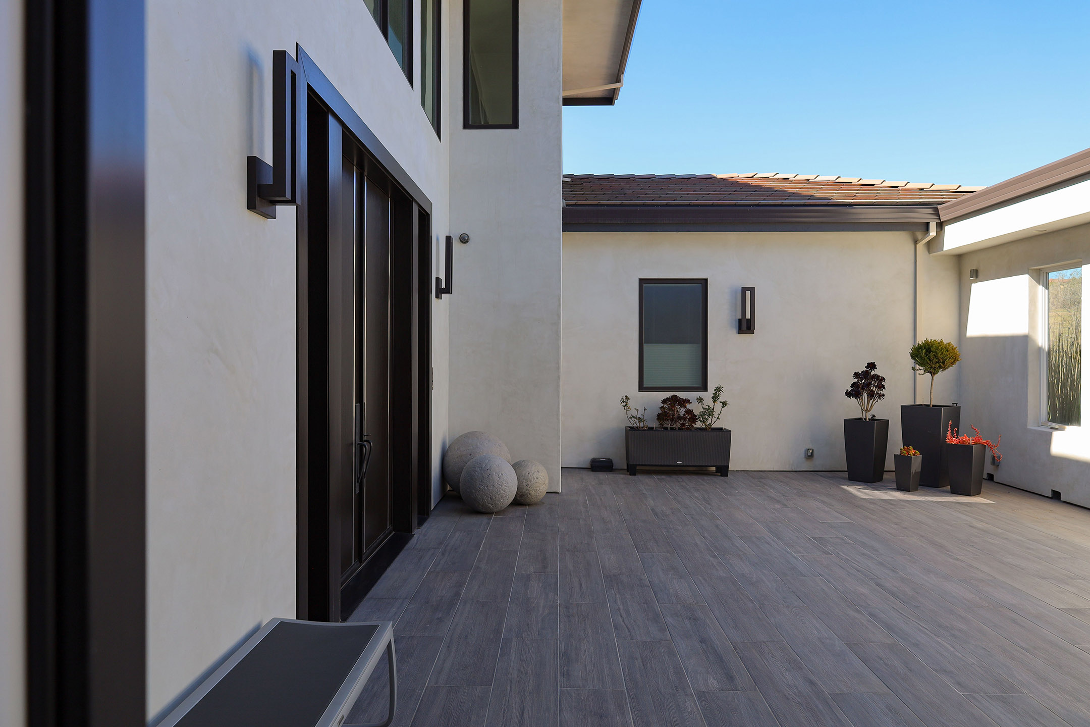 Indoor/outdoor living room looks out on pool and lawn