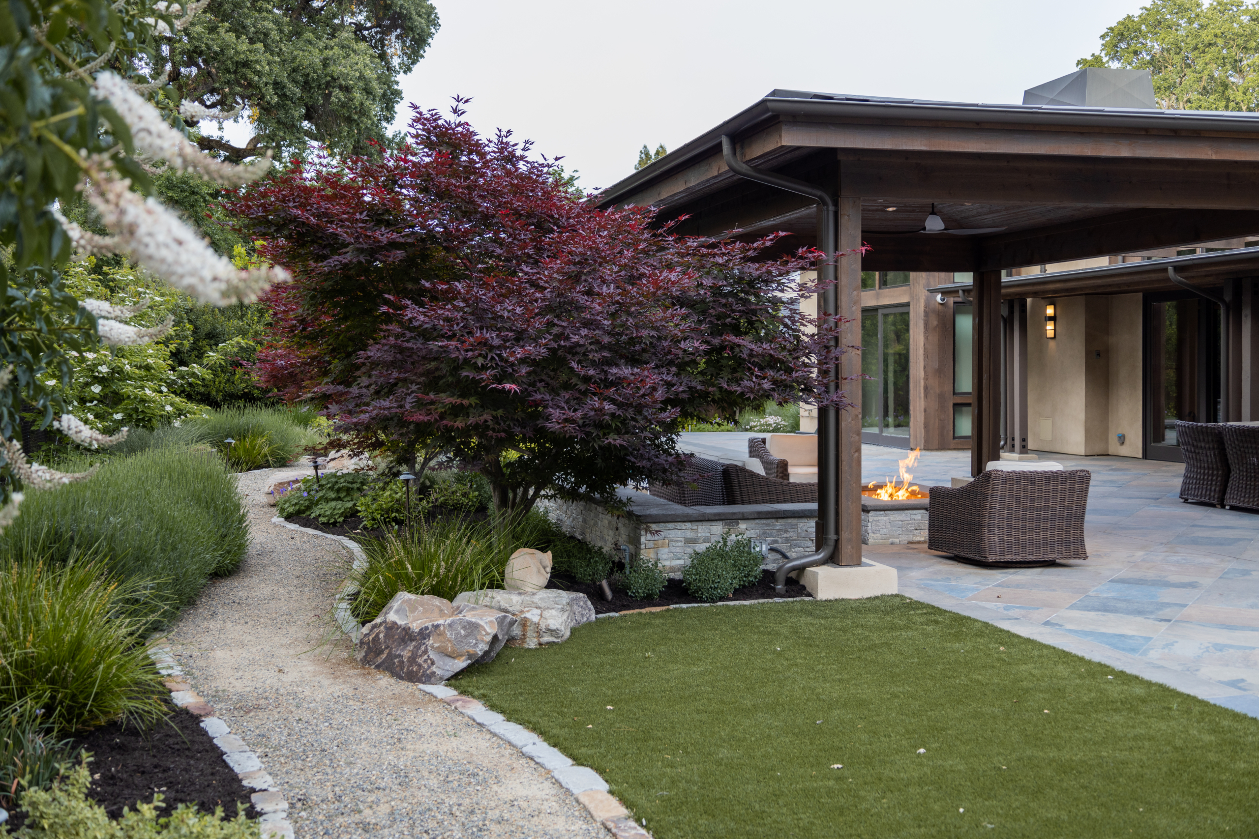 Gravel seating area with wooden lounge chairs and mountain views, designed by Montgomery Robbins